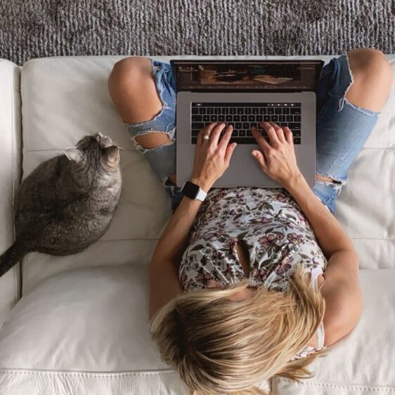 Een vrouw thuis aan het werk samen met haar kat.