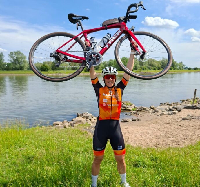 Anne-Wil met haar fiets boven het hoofd