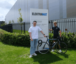 Foto van racende reported Douwe met Kyle van Asperen bij bord Elektramat