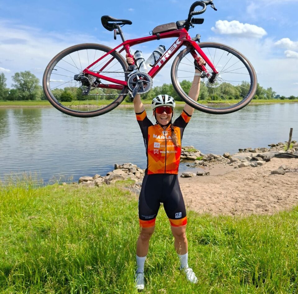 Anne-Wil met haar fiets boven het hoofd